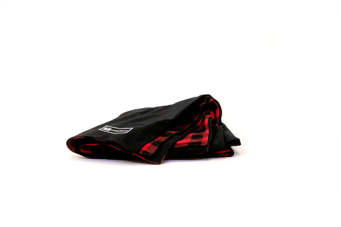 Side view of Denim Blanket Company black denim blanket with red buffalo check fleece lining