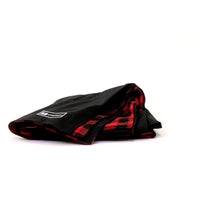 Side view of Denim Blanket Company black denim blanket with red buffalo check fleece lining