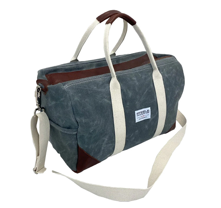 Side view of Steele Canvas slate colored canvas duffle gym travel bag with brown leather accents