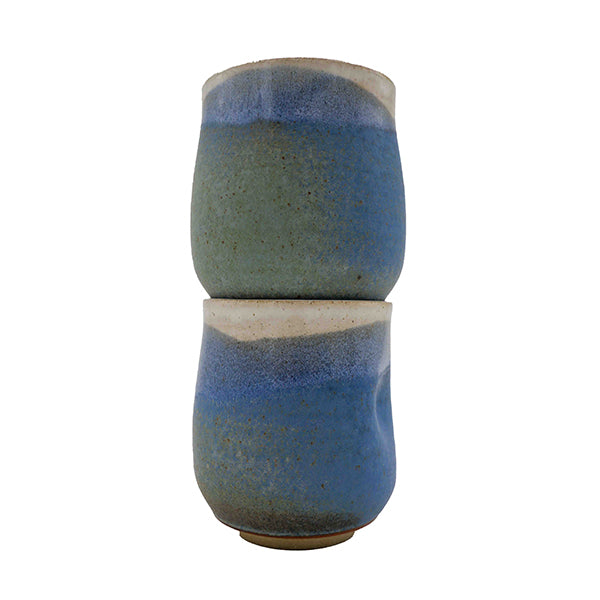 Side photo of stacked pair of stoneware wine mugs with blue, green, and cream glaze handmade by Allison Morrissey