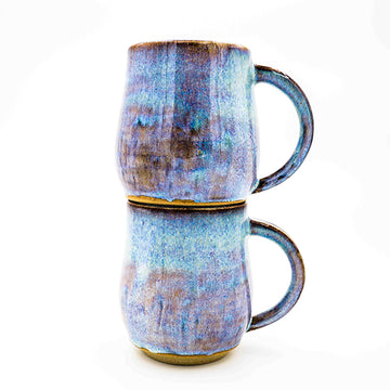 Side photo of stacked pair of stoneware mugs with periwinkle glaze handmade by Allison Morrissey