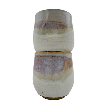 Side photo of stacked pair of stoneware wine mugs with pink and cream glaze handmade by Allison Morrissey