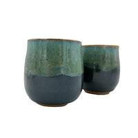 Side photo of side-by-side pair of stoneware wine mugs with teal glaze handmade by Allison Morrissey